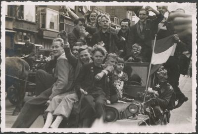 879272 Afbeelding van een Jeep, volgeladen met feestvierende burgers, vooral kinderen, tijdens de intocht van de ...